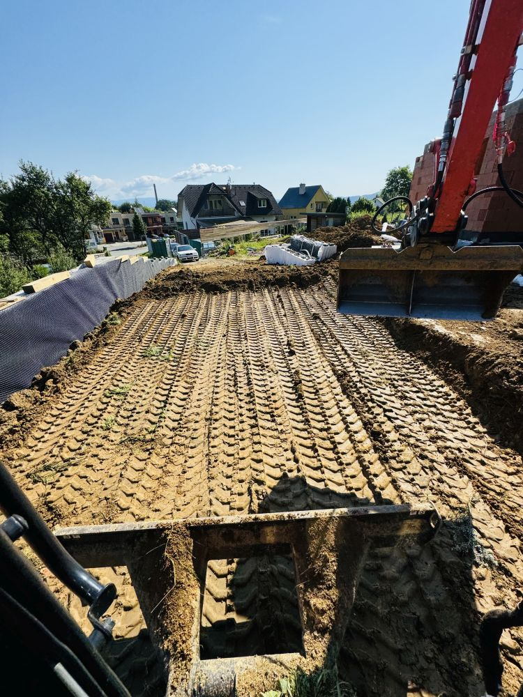 Srovnaná plocha pro stavbu nad obcí, svah zajištěný ochrannou fólií
